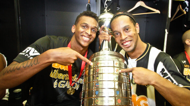 jô segurando a taça da libertadores ao lado de ronaldinho