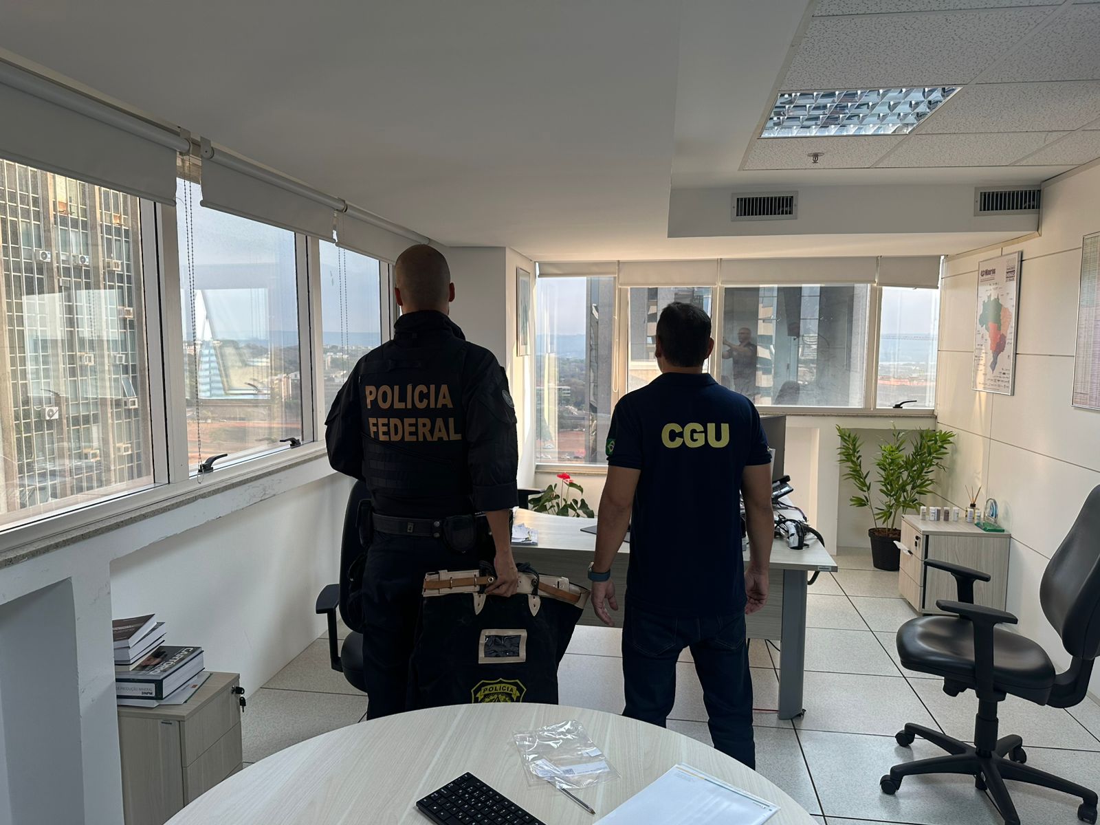 Dois agentes da PF e CGU, vistos de costas