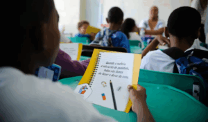 Uma imagem de uma sala de aula, com uma folha de papel em detalhe