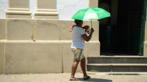 mulher cobrindo sol com sombrinha