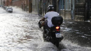 motociclista andando em rua alagada