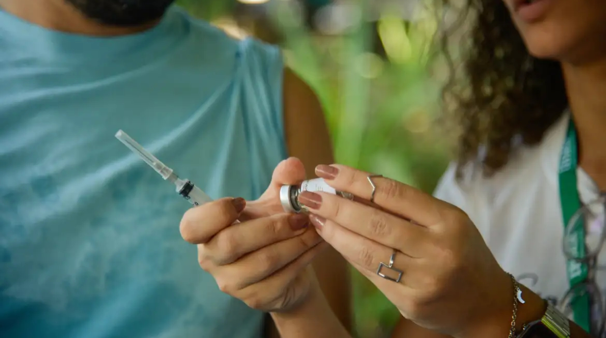 mulher segurando vacina