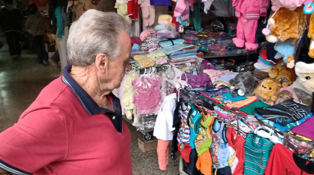 idoso comprando roupa de criança