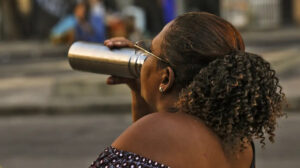 mulher se hidratando em um dia quente