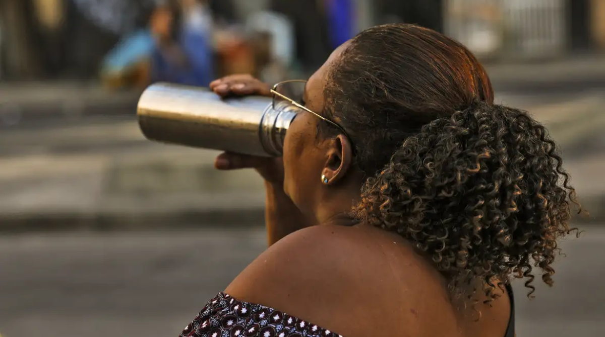 mulher se hidratando em um dia quente