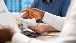 ITBI - mãos são vistas à frente de uma calculadora