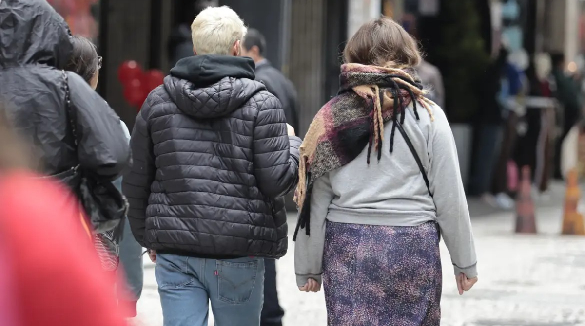 pessoas agasalhadas andando na rua