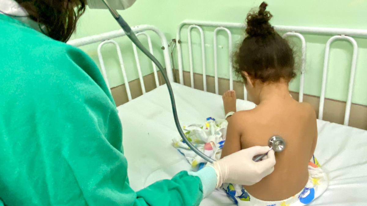 foto mostra médica checando respiração de criança bronquiolite