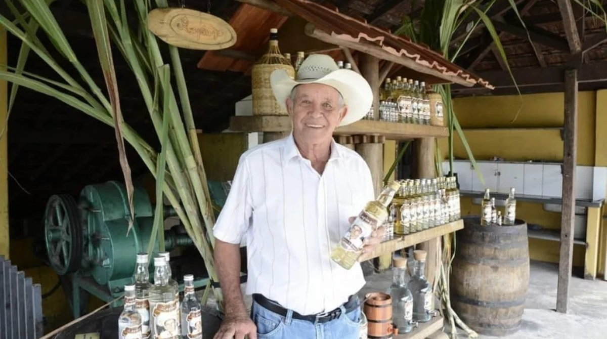 lapinha segurando uma garrafa de cachaça