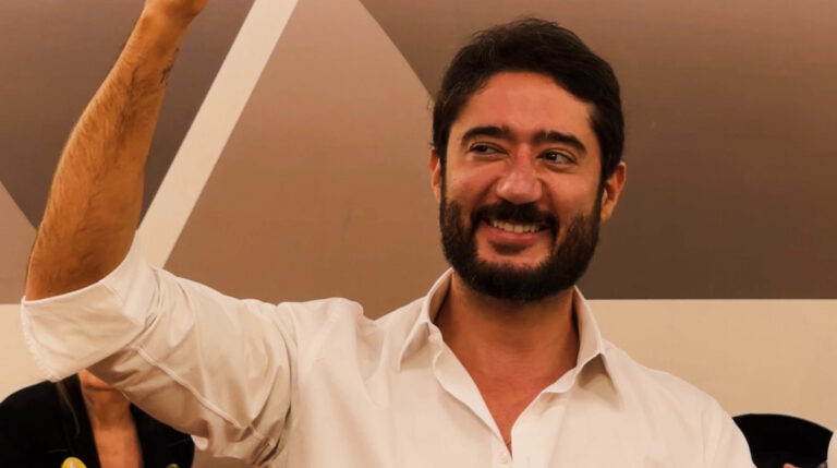 gabriel azevedo sorrindo enquanto segura uma placa