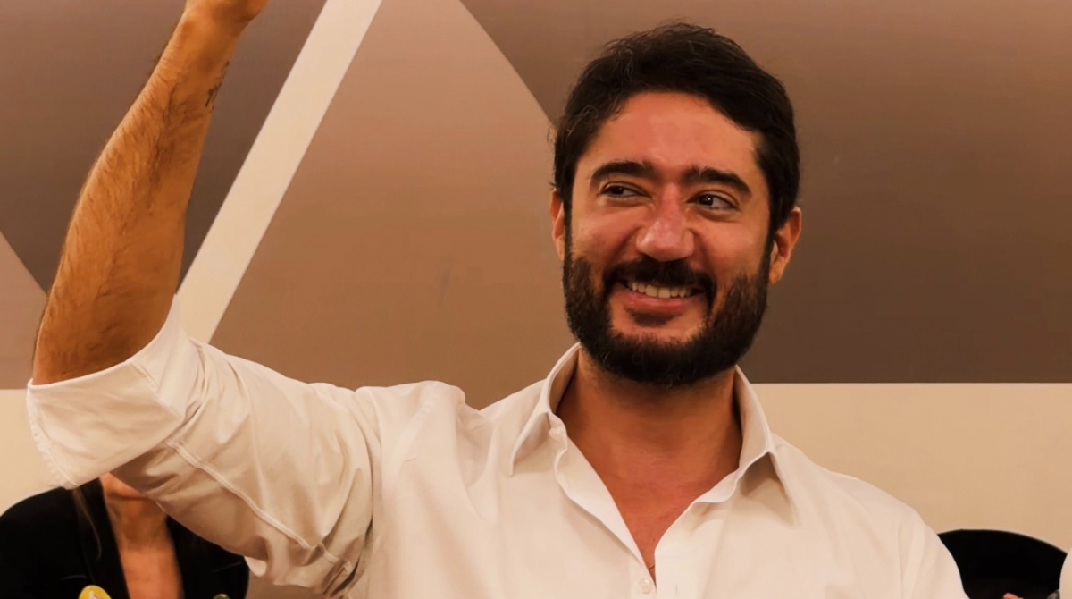 gabriel azevedo sorrindo enquanto segura uma placa