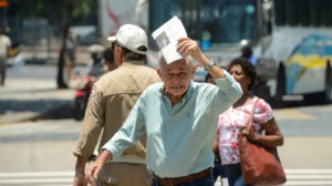 homem idoso na rua debaixo do sol quente