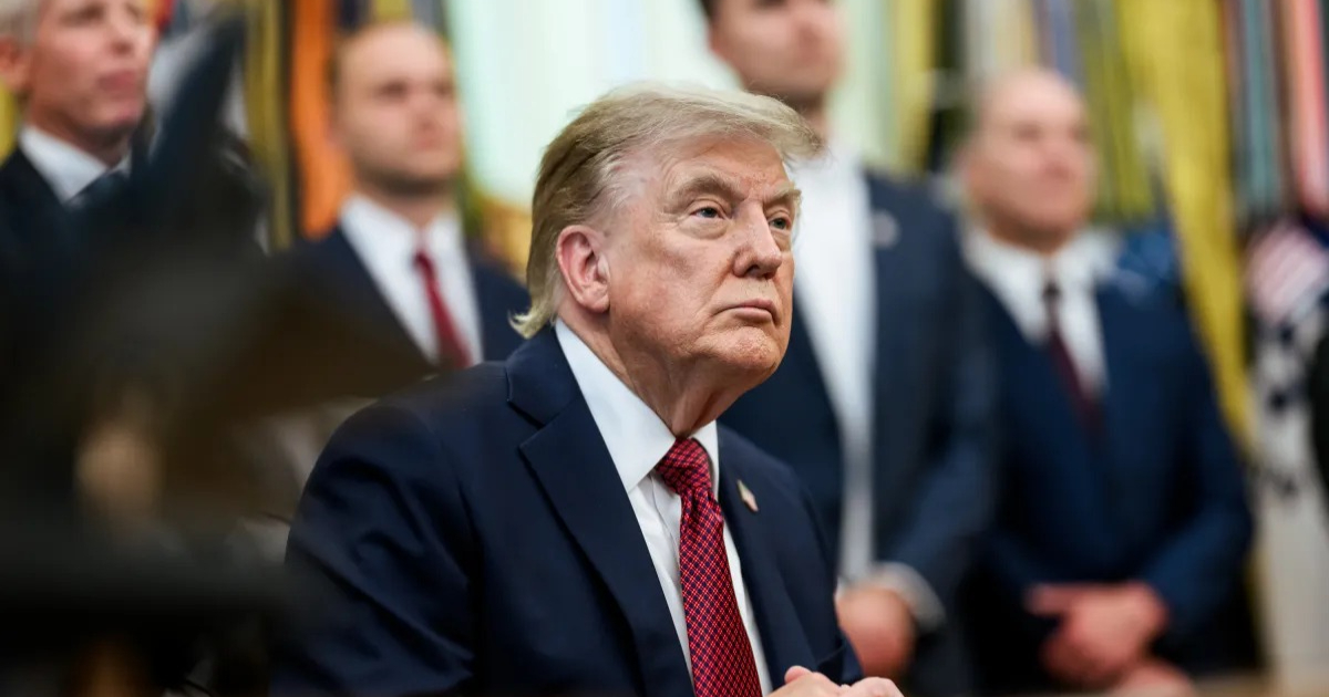 trump sentado com expressão séria